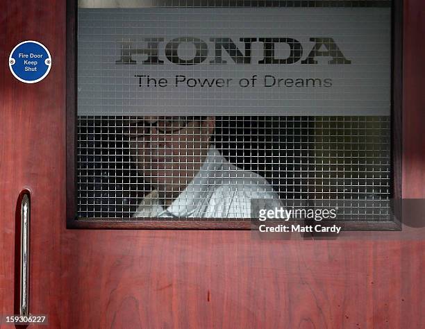 Honda worker looks out of a window in a office building at the Honda car assembly plant following the announcement that the firm is to axe 800 jobs...