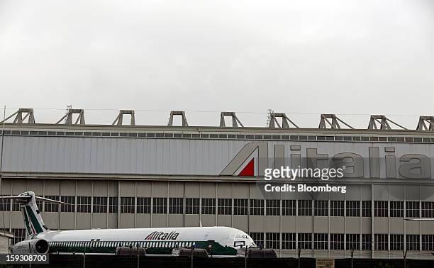Protective covers sit on the cockpit windows of an Alitalia SpA aircraft parked outside a hangar at Fiumicino airport in Rome, Italy, on Friday, Jan....