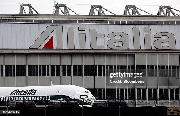 Protective covers sit on the cockpit windows of an Alitalia SpA aircraft parked outside a hangar at Fiumicino airport in Rome, Italy, on Friday, Jan....