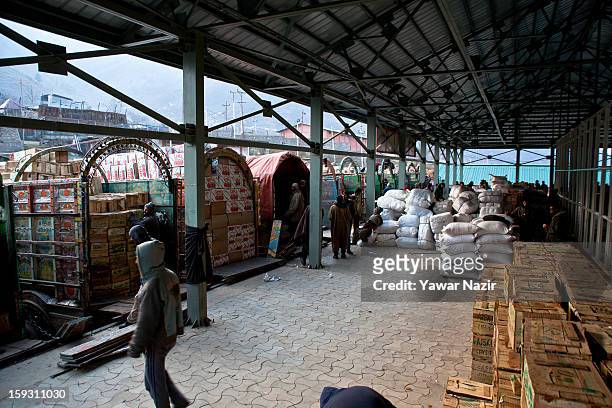 Workers unload goods from Pakistani vehicles at the trade facilitation centre in the border area near Uri on January 11, 2013 in Salamabad, 120 km...