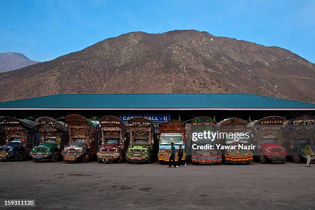 Pakistani vehicles unload their goods at the trade facilitation centre in the border area near Uri on January 11, 2013 in Salamabad, 120 km northwest...