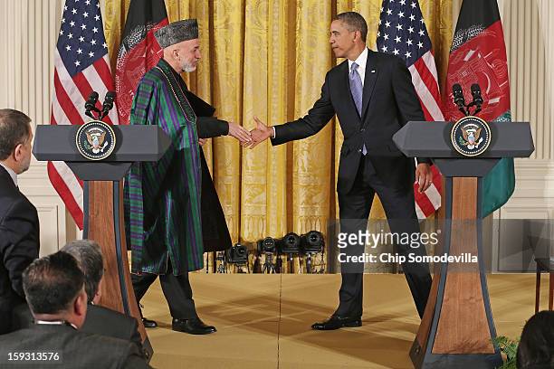 Afghan President Hamid Karzai and U.S. President Barack Obama shake hands after holding a joint news conference in the East Room of the White House...
