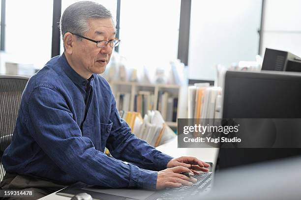 senior man working on a computer in the office - japanese ol stockfoto's en -beelden