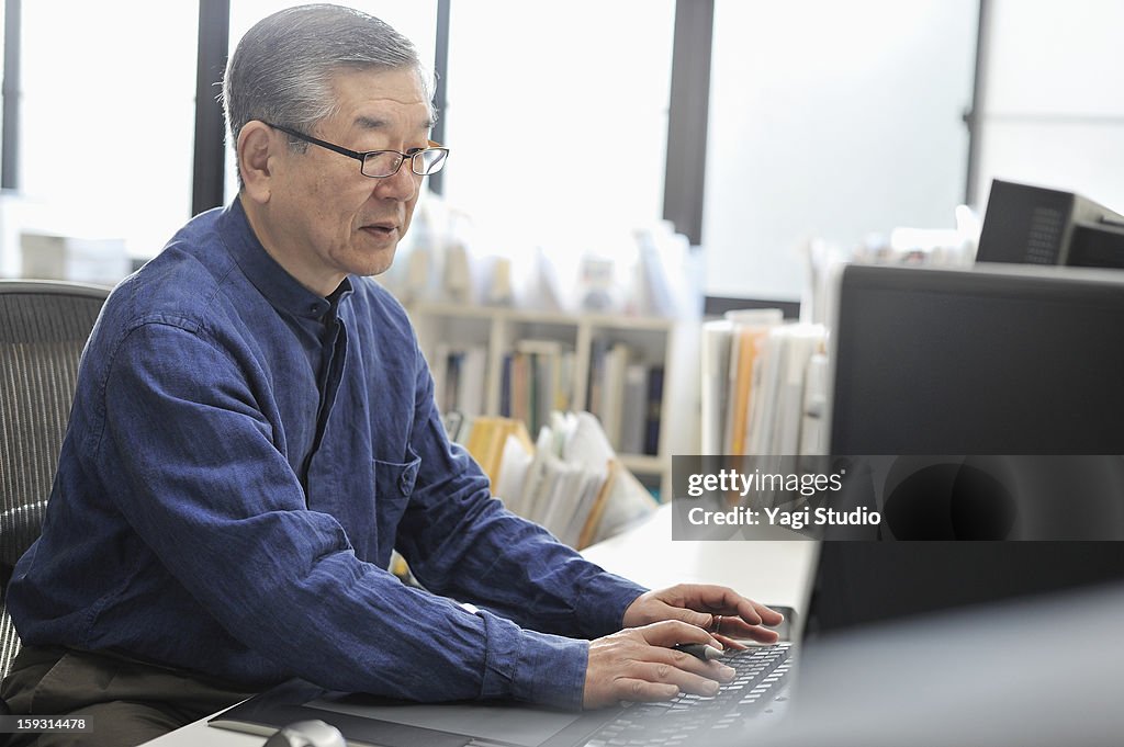 Senior man working on a computer in the office