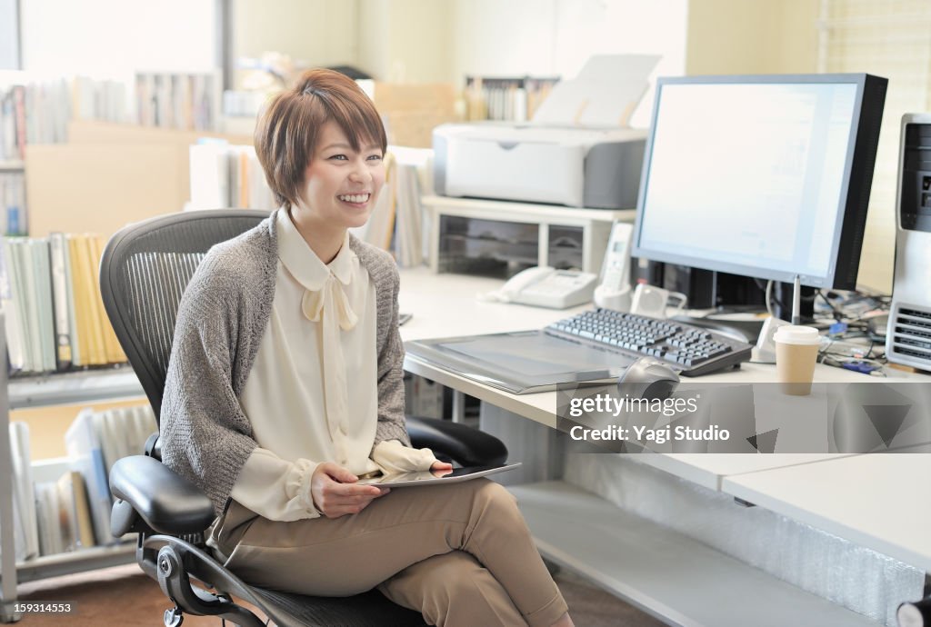 Businesswoman sitting in office,smiling