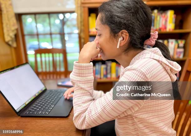 multiracial young woman using laptop in library - college admission stock pictures, royalty-free photos & images