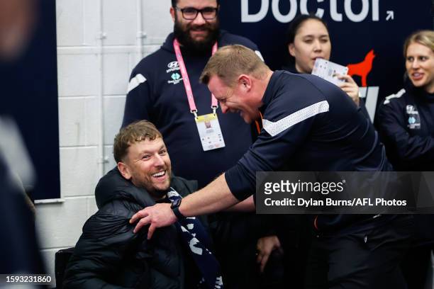 Dylan Alcott celebrates with Michael Voss, Senior Coach of the Blues during the 2023 AFL Round 22 match between the Carlton Blues and the Melbourne...