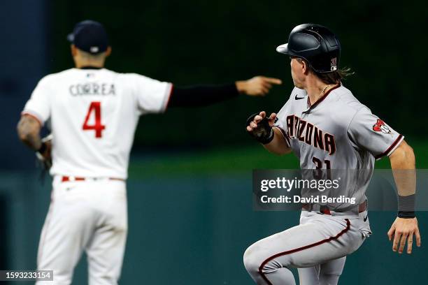 Jake McCarthy of the Arizona Diamondbacks advances to third base on a single by teammate Alek Thomas while Carlos Correa of the Minnesota Twins...