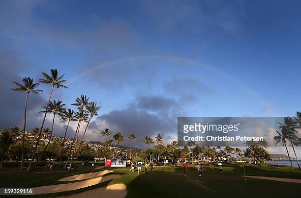 Justin Hicks, Josh Persons and Shawn Stefani approach the 17th green under a rainbow during the second round of the Sony Open in Hawaii at Waialae...