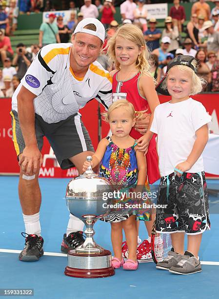 Lleyton Hewitt of Australia poses with the winners trophy and his children Ava Hewitt, Cruz Hewitt and Mia Hewitt after winning his match against...