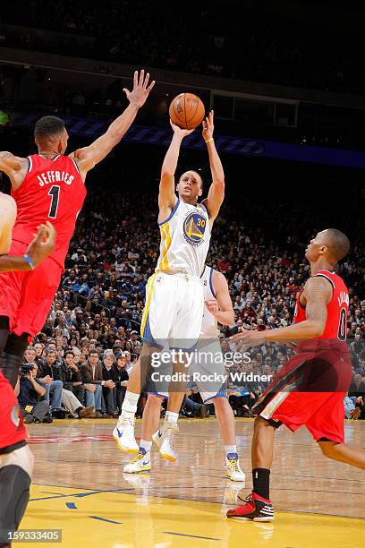 Stephen Curry of the Golden State Warriors shoots against Jared Jeffries of the Portland Trail Blazers on January 11, 2013 at Oracle Arena in...