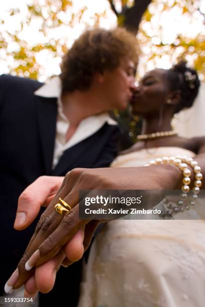 Mixed couple, husband and wife kissing hand in hand during interracial marriage on October 1, 2005 in Paris, France.