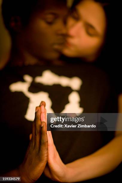 Young mixed interracial couple in love joining hands for praying on March 23, 2008 in Paris, France.