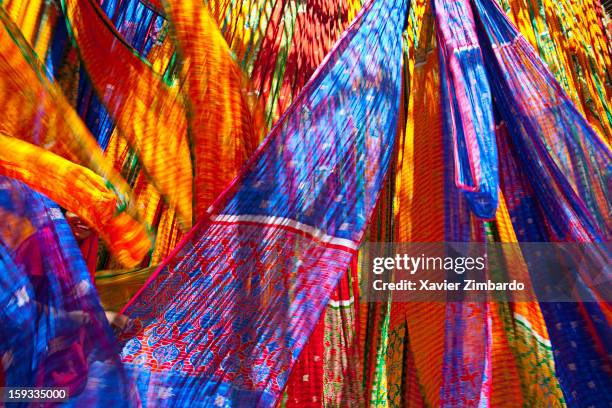 Fabrics being air dried at a dyeing workshop, while a woman worker is pulling and folding a length of fabric on April 6, 2009 in Rajasthan, India.