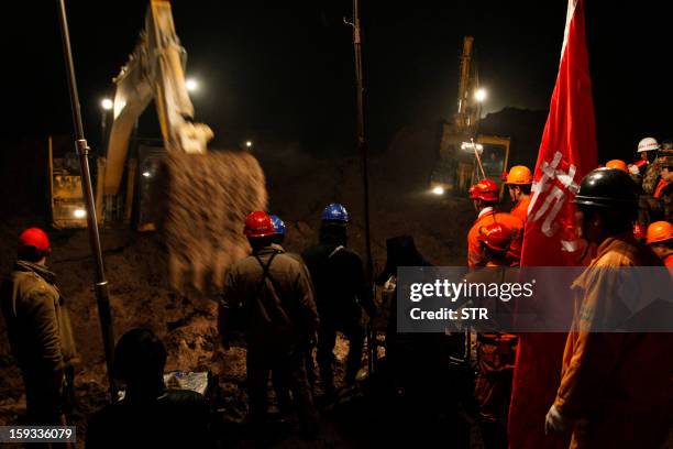 This picture taken late on January 11, 2013 shows rescuers searching for buried residents in disaster-hit Gaopo village, southwest China's Yunnan...