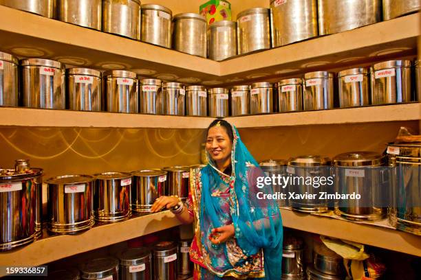 Grooms mother collecting grocery items from the grocery store room inside the Sancheti house kitchen for the "Puja", a ritual marking the start of...