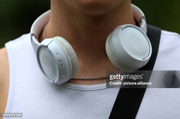 August 2023, Bavaria, Würzburg: A young man wears headphones around his neck. August 12 is International Youth Day. Photo: Karl-Josef Hildenbrand/dpa