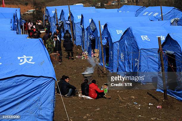 Residents gather near temporary tents after the rescue mission is finished in the disaster-hit area in Gaopo village, southwest China's Yunnan...