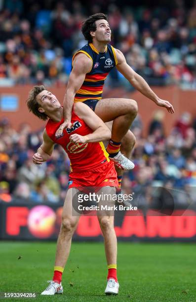 Darcy Fogarty of the Crows gets the sit on Charlie Ballard of the Suns during the round 21 AFL match between Adelaide Crows and Gold Coast Suns at...
