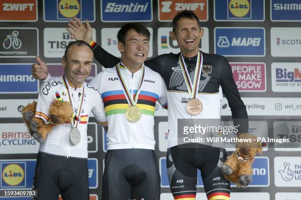 China's Weicong Liang poses with his medal after winning the Men's C1 Road Race, alongside Spain's Ricardo Ten Argiles with silver and Germany's...