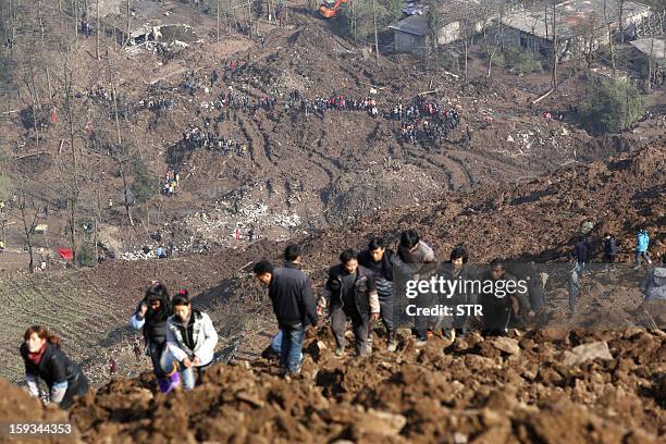 Local residents go to check the collapsed hill in the disaster-hit area to see how the landslide happened in Gaopo village, southwest China's Yunnan...