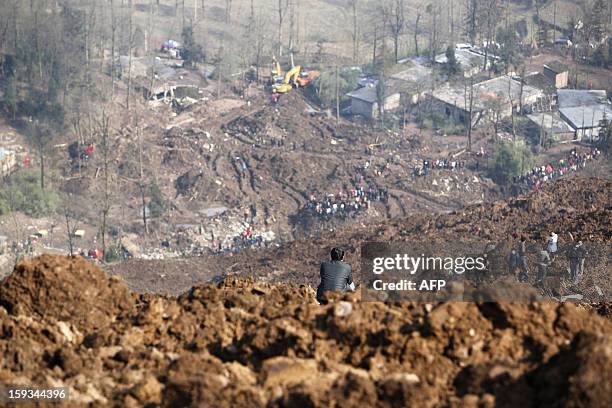 Local resident stands on the collapsed hill in the disaster-hit area to see how the landslide happened in Gaopo village, southwest China's Yunnan...