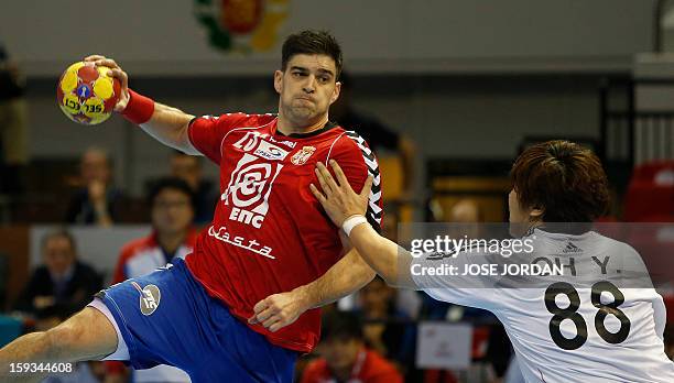 Serbia's back Nenad Vuckovic vies for the balla with Korea's back Yun-Suk Oh during the 23rd Men's Handball World Championships preliminary round...