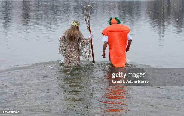 Ice swimming enthusiasts dressed as Neptune and a carrot enter the cold waters of Orankesee lake during the 'Winter Swimming in Berlin' event on...
