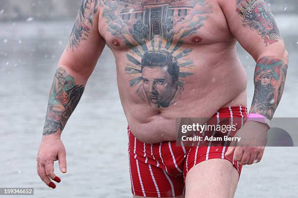 An ice swimming enthusiast with a tattoo of Elvis wades in the cold waters of Orankesee lake during the 'Winter Swimming in Berlin' event on January...