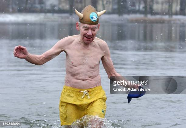 An ice swimming enthusiast from Denmark dressed as a viking wades in the cold waters of Orankesee lake during the 'Winter Swimming in Berlin' event...