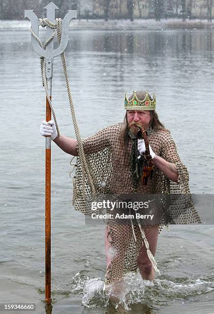 An ice swimming enthusiast dressed as Neptune leaves the cold waters of Orankesee lake during the 'Winter Swimming in Berlin' event on January 12,...