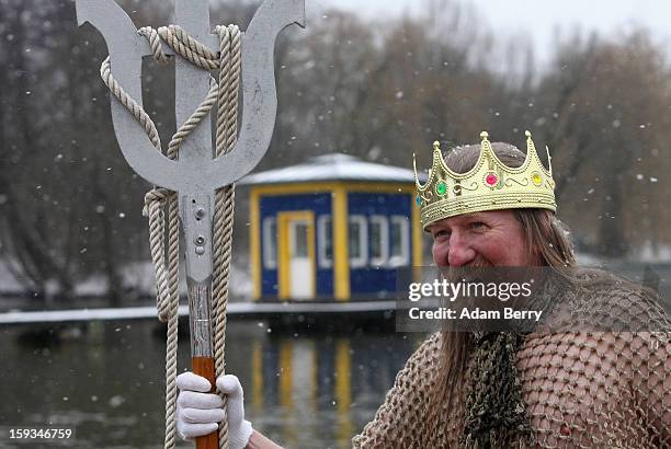 An ice swimming enthusiast dressed as Neptune prepares to enter the cold waters of Orankesee lake during the 'Winter Swimming in Berlin' event on...