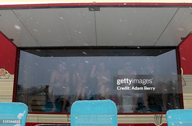 Ice swimming enthusiasts sit inside a mobile sauna after wading in the cold waters of Orankesee lake during the 'Winter Swimming in Berlin' event on...