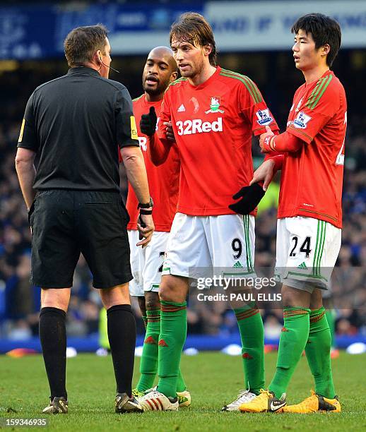 Swansea City's Spanish midfielder Miguel Michu speaks to referee Phil Dowd during the English Premier League football match between Everton and...