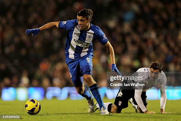 Franco Di Santo of Wigan pulls away from Aaron Hughes of Fulham during the Barclays Premier League match between Fulham and Wigan Athletic at Craven...