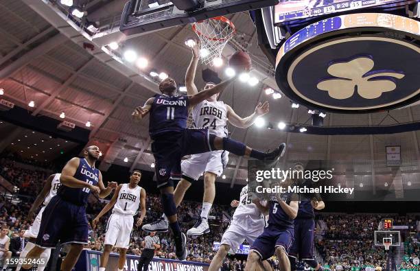 Ryan Boatright of the Connecticut Huskies shoots under the basket as Pat Connaughton of the Notre Dame Fighting Irish defends at Purcel Pavilion on...