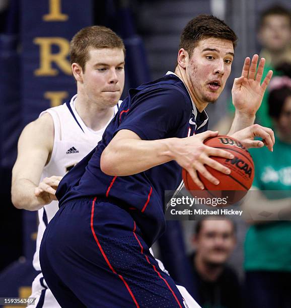 Tyler Olander of the Connecticut Huskies dribbles the ball against Scott Martin of the Notre Dame Fighting Irish at Purcel Pavilion on January 12,...