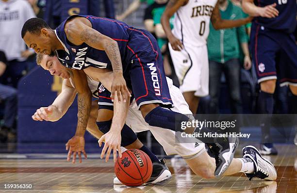 Scott Martin of the Notre Dame Fighting Irish and Ryan Boatright of the Connecticut Huskies battle for a loose ball at Purcel Pavilion on January 12,...