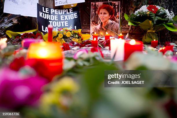 Candles and flowers are seen in front of the Kurdistan Information Bureau in Paris, on January 11 a day after three Kurdish women were found shot...