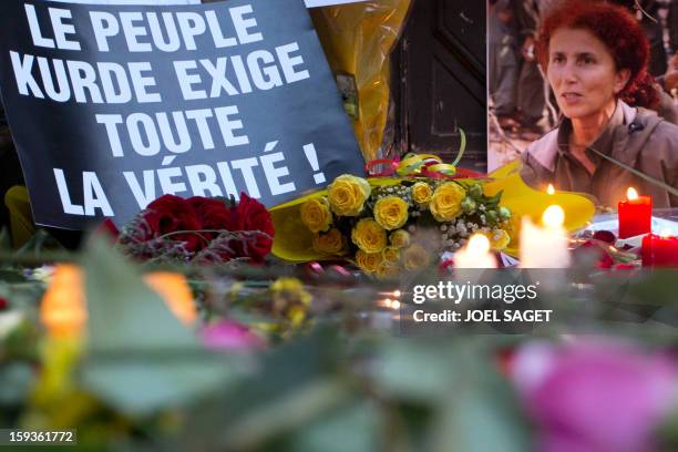 Candles and flowers are seen in front of the Kurdistan Information Bureau in Paris, on January 11 a day after three Kurdish women were found shot...