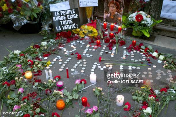 Candles and flowers are seen in front of the Kurdistan Information Bureau in Paris, on January 11 a day after three Kurdish women were found shot...