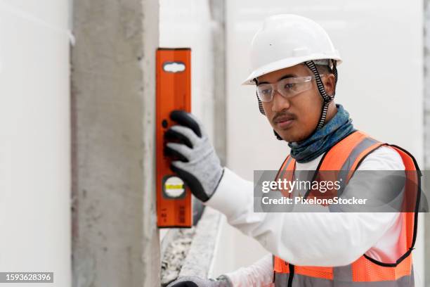 worker doing verify the wall alignment to ensure before further process doing wall tile work. - further stock pictures, royalty-free photos & images