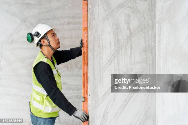 worker doing verify the wall alignment to ensure before further process doing wall tile work. - further stock pictures, royalty-free photos & images