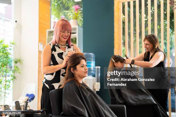 hairdressers working in a hair salon - haar knippen stockfoto's en -beelden