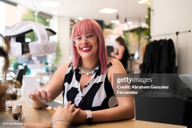 happy hairdresser polishing the nails of a client - celebrity stylist stock pictures, royalty-free photos & images