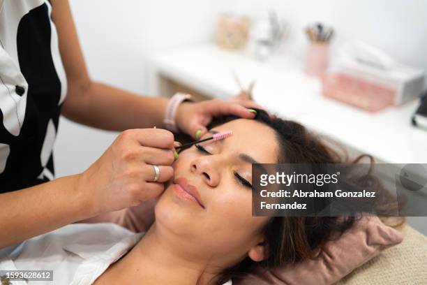 hairdresser combing the eyebrows of a client - female body waxing stock pictures, royalty-free photos & images