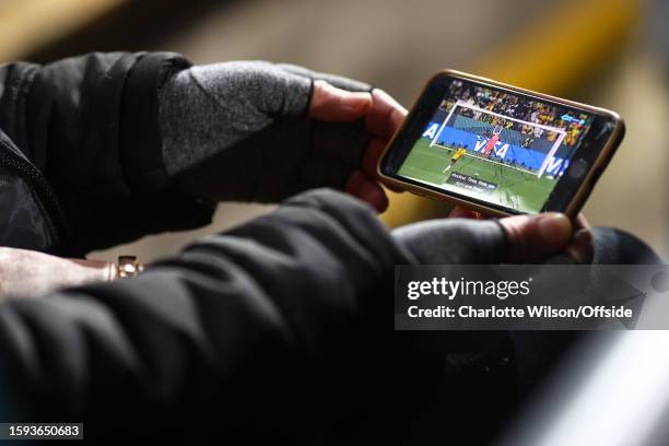 Fan watches the penalty shoot-out between Australia and France on their phone during the FIFA Women's World Cup Australia & New Zealand 2023 Quarter...
