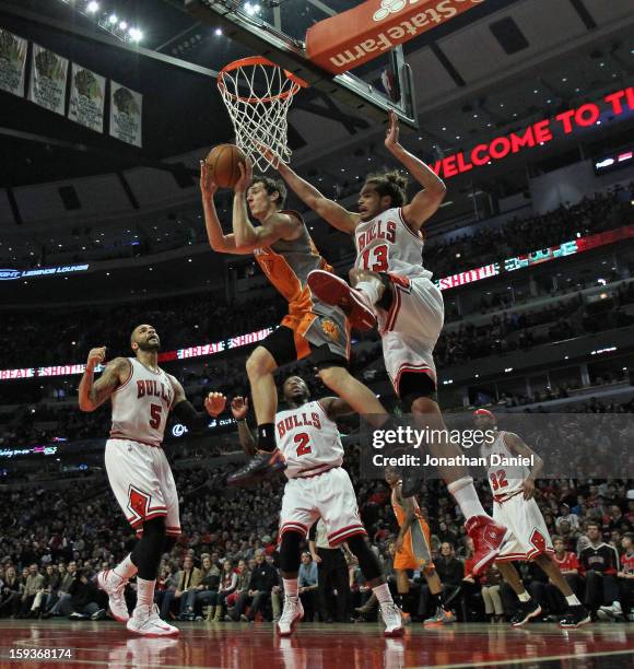 Goran Dragic of the Phoenix Suns leaps to pass over Carlos Boozer, Nate Robinson and Joakim Noah of the Chicago Bulls at the United Center on January...