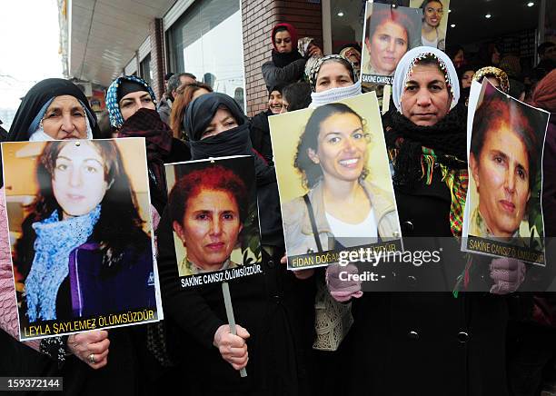 Kurdish women hold on January 12, 2013 portraits of the slain founding member of the Kurdistan Workers' Party , Sakine Cansiz , Leyla Soylemez and...