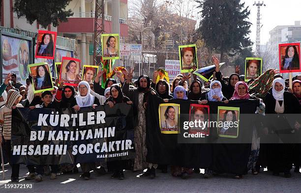 Kurdish women hold on January 12, 2013 portraits of the slain founding member of the Kurdistan Workers' Party , Sakine Cansiz, Fidan Dogan and Leyla...